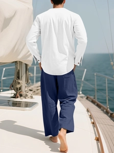 Rückansicht eines weißen Leinenhemdes und blauer Hose für Herren auf einem Segelboot