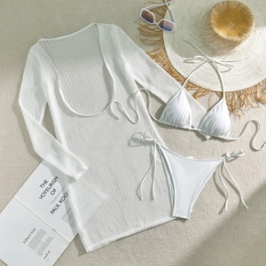 Detailed flat lay of white crochet beach cover-up dress with matching bikini set