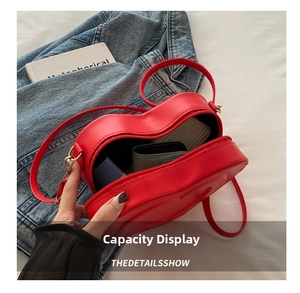 Top view of red heart-shaped shoulder bag interior capacity with golden hardware