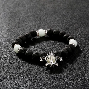 Luminous turtle bead bracelet with black volcanic stones and silver crown accent