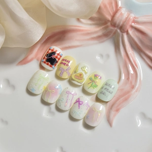 Detail of sweet 3D bow and rabbit nail stickers on a decorative white porcelain plate