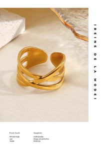 Detail of 18K gold plated multi-layer crisscross ring on white marble and glass background
