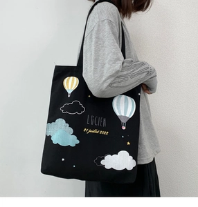 Détail d'un grand sac cabas en toile noire avec imprimé montgolfière coloré et longues anses