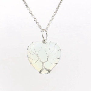 Macro shot of silver wire-wrapped tree of life on heart-shaped moonstone pendant