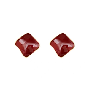 Minimalist square geometric earrings in deep red glaze with gold plating on white backdrop