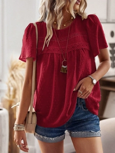 Detail of red crew neck top with hollow-out embroidery and short sleeves on model