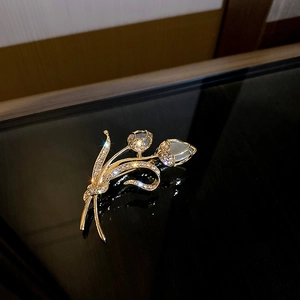 Broche tulpe élégante en or avec pétales d'opale et diamants sur une surface noire