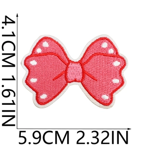 Macro detail of pink polka dot embroidered bow patch with size 4.1x5.9cm measurements