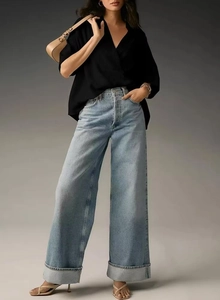 Close-up of light blue high-waisted wide-leg jeans with washed denim texture detail