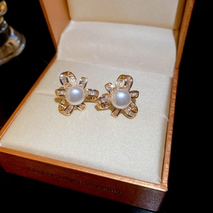 Detailed close-up of pearl studs with zircon flower base in a luxury jewelry box
