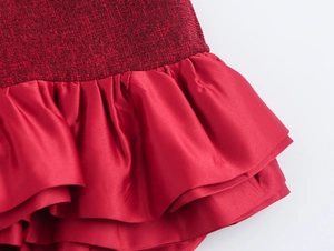 Dettaglio di patchwork in tweed rosso con orlo a balze in raso sull'abito corto