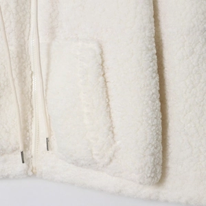 Close-up of white fleece baseball jacket with textured sherpa fabric and metal drawstrings
