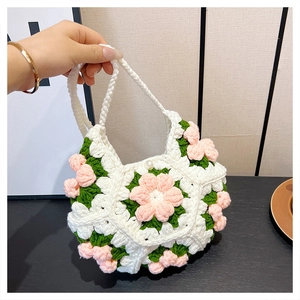 Detail of handmade white crochet shoulder bag with pink 3D flowers and pearl button