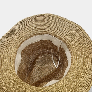 Detail of the golden straw sun hat showing interior ribbed sweatband and adjustable strap