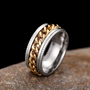 Detailed macro view of rotatable gold chain on silver textured steel ring