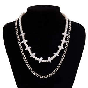 Close-up of double layer necklace with irregular white pearls and silver metal chain link