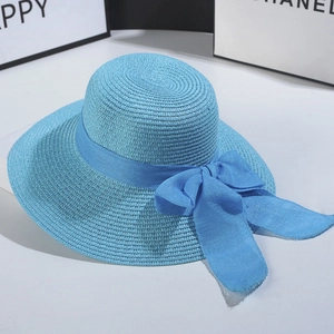 Detail of blue straw sun hat with wide brim and elegant matching bow ribbon