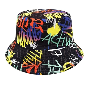 Detail shot of the black bucket hat featuring colorful graffiti and brick patterns