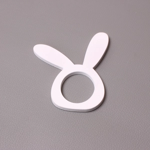 Detail view of a white rabbit napkin ring on a grey leather texture background