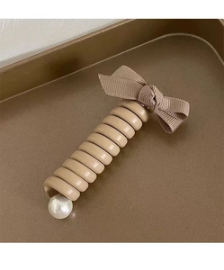 Détail d'un élastique spirale kaki avec nœud beige côtelé et perle artificielle