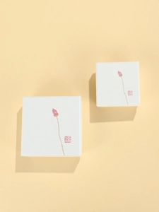 Detailed view of white square jewelry gift box with Zen lotus pattern and red seal art