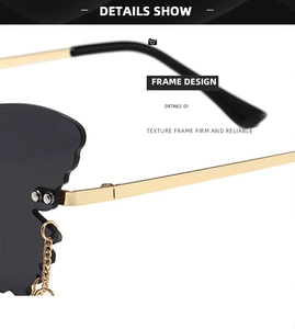 Detail of trendy butterfly sunglasses with golden metal hinges and wavy rimless dark lenses