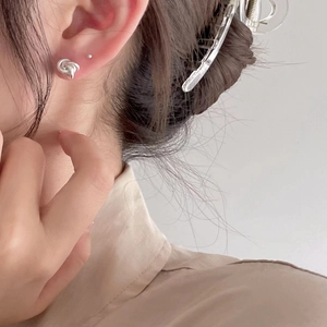 Primo piano di orecchini a nodo minimalisti in argento sterling per un look elegante