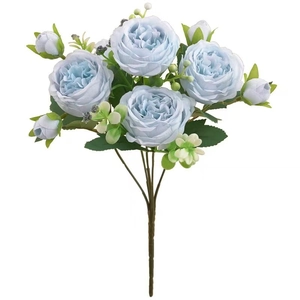 Close-up of artificial blue roses with green leaves and stems for home floral decoration