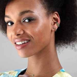 Detail of bohemian gold earring set and fine necklace featuring turquoise accents