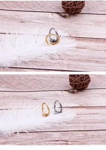 Detailed close-up of retro gold and silver snake-textured rings on rustic wooden floor