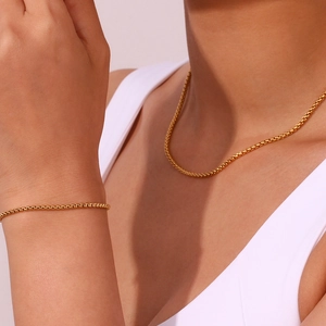 Detailed view of 18K gold-plated stainless steel box chain necklace and bracelet on model