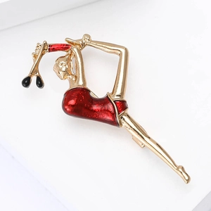 Detailed view of rhythmic gymnast brooch with gold metal and red enamel on white base