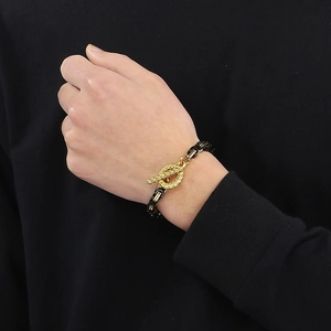 Detail of black and gold stainless steel chain bracelet with OT toggle clasp on wrist