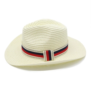 Detail view of woven straw cowboy hat featuring a tricolor band with meander patterns