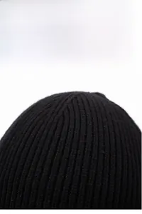 Detail of black ribbed knit beanie showing thick warm texture and vertical weaving pattern