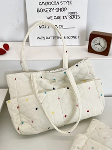 Off-white quilted tote bag with colorful heart embroidery and front pocket by Soxakka