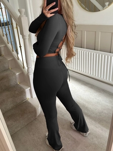Back view of black Y2K yoga set showing high waist leggings and lace-up long sleeve top
