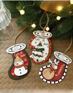 Detail of painted wooden Christmas ornaments with reindeer and snowman on pine branches