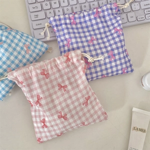 Three-piece checkered drawstring pouches in pink, blue, and purple with bow details
