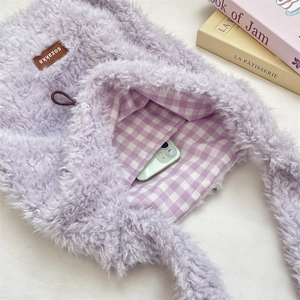 Detail view of plush tote bag interior featuring lavender checkered lining and a phone pocket