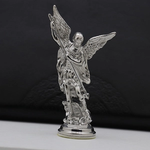 Detailed close-up of Saint Michael vintage metal statue fighting a dragon on base