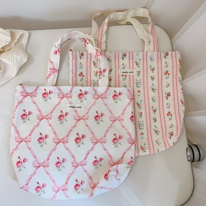 Détail de sacs fourre-tout en coton à fleurs et rayures avec étiquette tissée