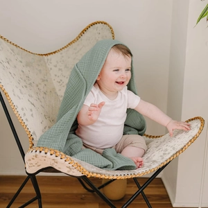Detailed texture of sage green muslin cotton baby hooded towel with soft breathable gauze