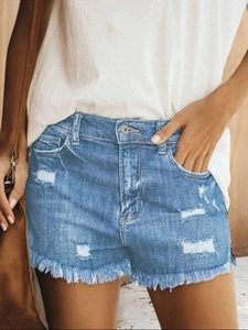 Detail von Jeansshorts mit Löchern und ausgefranstem Fransen-Saum an der Frau
