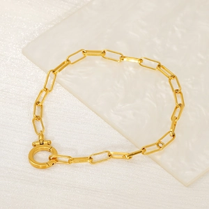 Detailed close-up of 18K gold-plated paperclip link bracelet with round spring clasp