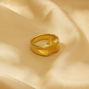 Detail of 18K gold plated star ring on a champagne silk fabric background