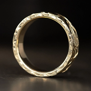 Vintage gold ring with intricate floral relief and textured ethnic pattern carving