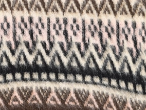 Close-up of Fair Isle geometric jacquard knit fabric with soft wool texture details