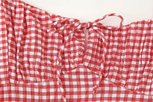 Detail of red and white plaid fabric with texture and delicate bow tie strap