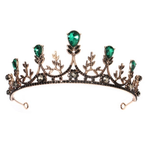 Detailed macro view of vintage bronze crown featuring green teardrop gems and black crystals
